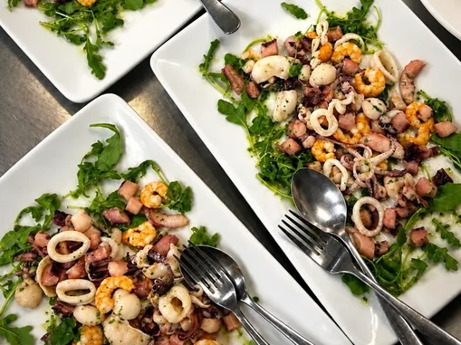 Piatto di pesce con insalata di mare, polpo, gamberi e calamari su rucola