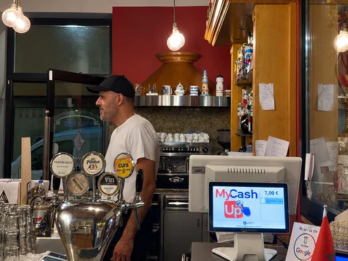 Bancone del bar con le spine della birra alla spina, la macchina del caffè e la cassa